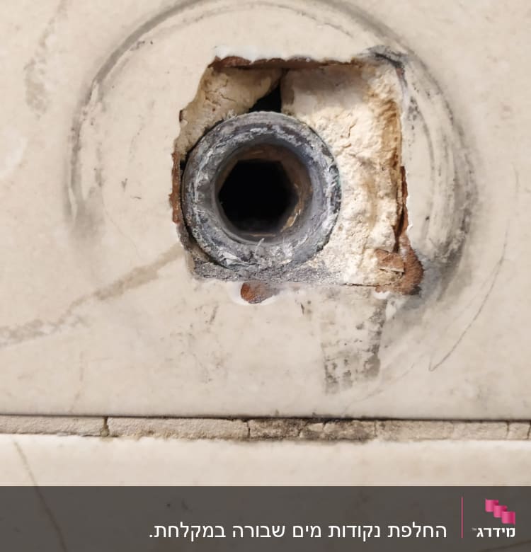 צינור מתכת חשוף בקיר עם חור